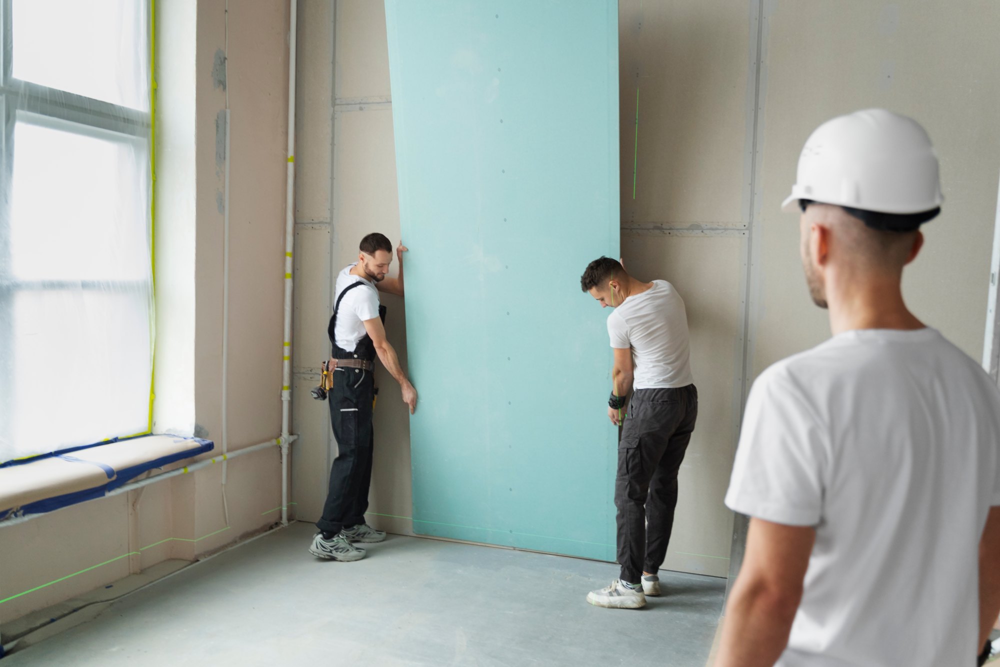 Rénovation complète d'appartement : artisans posant une cloison